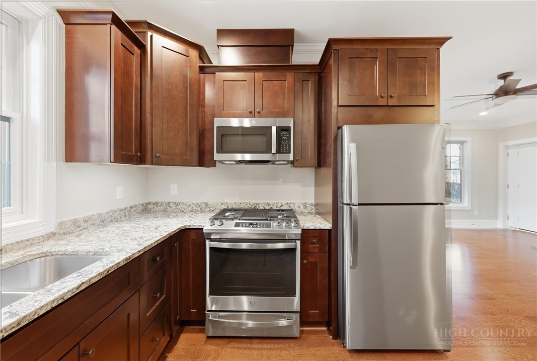155 Gateway Drive, Unit 101 Boone, NC 28607 - Photo 9 of 50 a kitchen with granite countertop a refrigerator a stove a microwave and cabinets