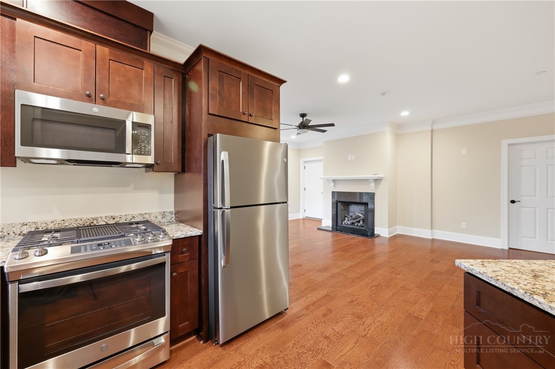 155 Gateway Drive, Unit 101 Boone, NC 28607 - Photo 10 of 50 a kitchen with granite countertop a stove top oven a refrigerator and a microwave