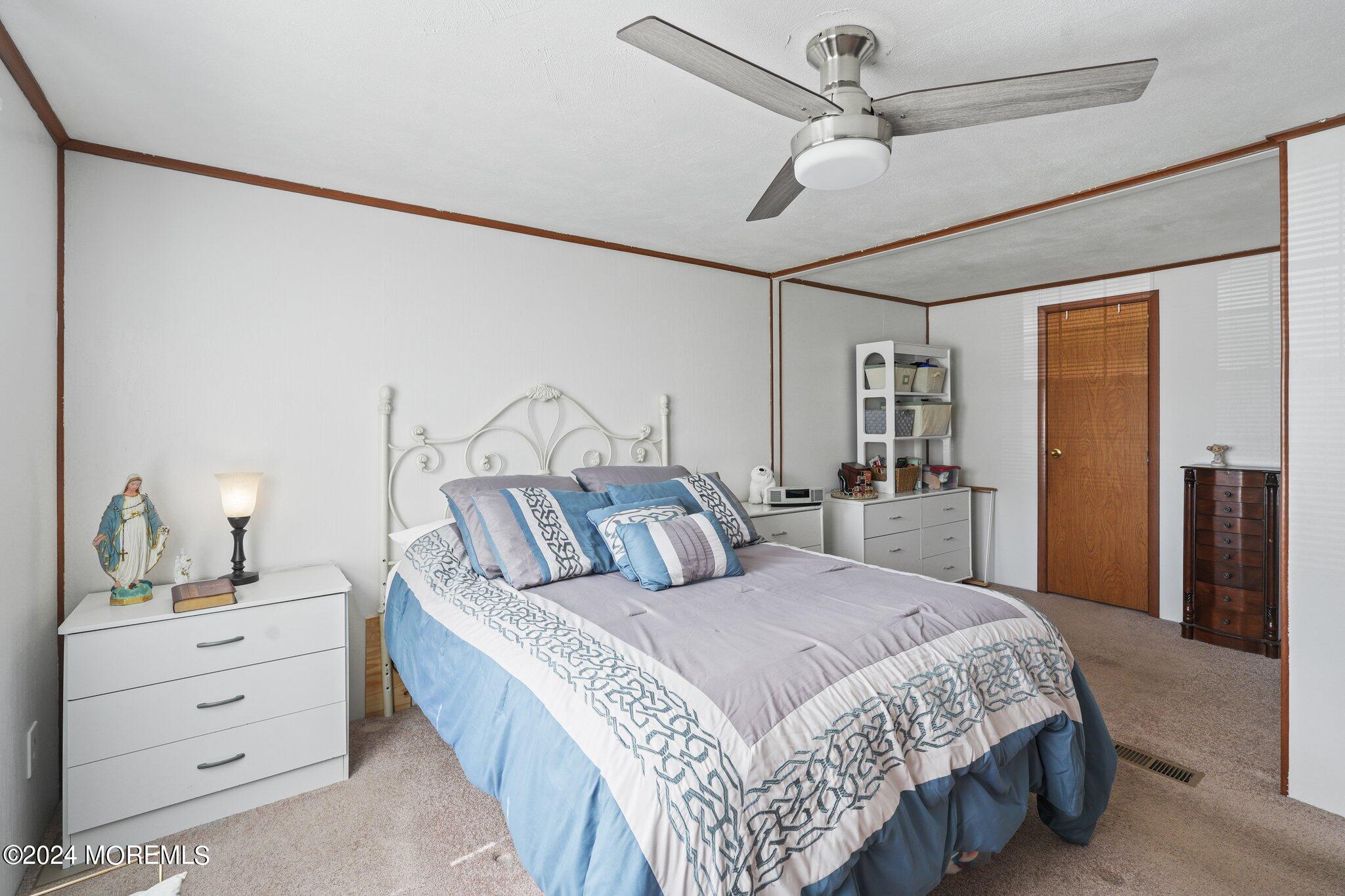 497 Rosalind Road Freehold, NJ 07728 - Photo 12 of 23 a bedroom with a large bed and a chandelier fan
