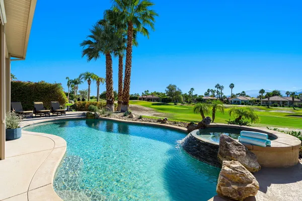 a view of swimming pool with outdoor seating and plants