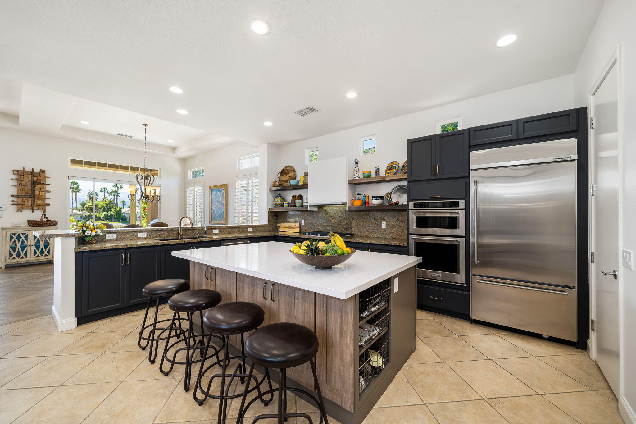 96 Vía Bella Rancho Mirage, CA 92270 - Photo 2 of 60 a kitchen with stainless steel appliances kitchen island granite countertop a refrigerator a stove a sink a dining table and chairs