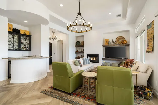 a living room with furniture a flat screen tv and a chandelier