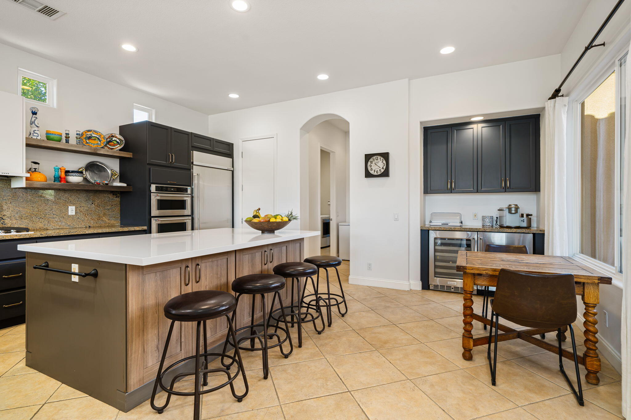 96 Vía Bella Rancho Mirage, CA 92270 - Photo 35 of 60 a kitchen with stainless steel appliances a dining table chairs and a refrigerator