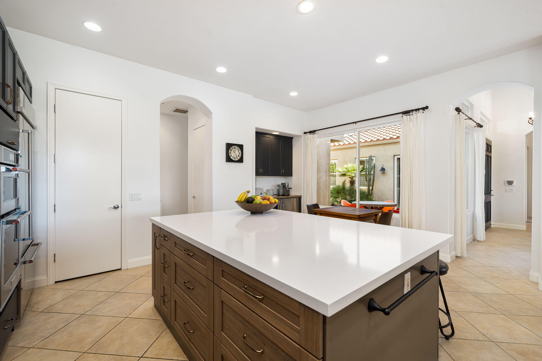 96 Vía Bella Rancho Mirage, CA 92270 - Photo 37 of 60 a kitchen with sink a refrigerator and chairs
