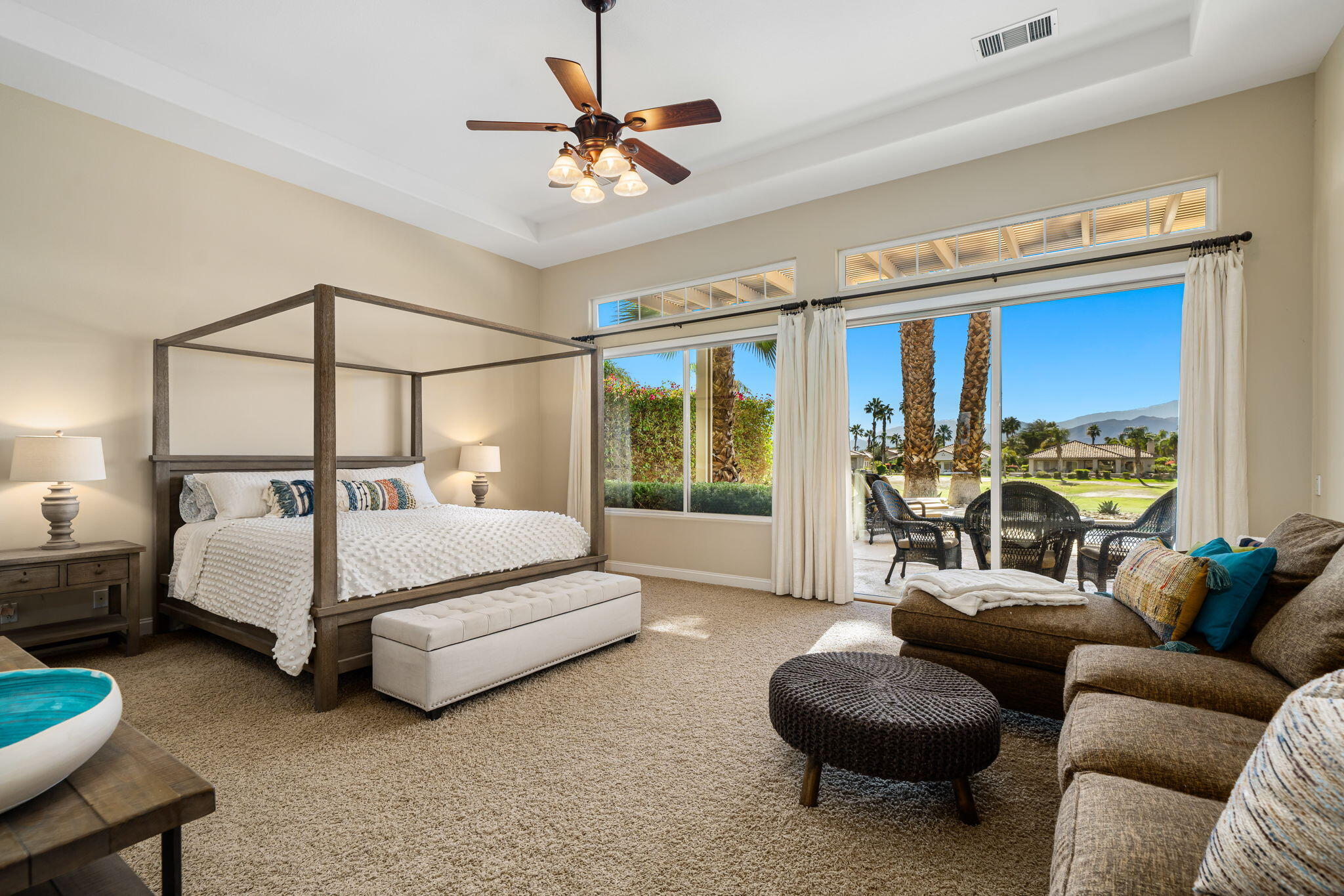 96 Vía Bella Rancho Mirage, CA 92270 - Photo 4 of 60 a bedroom with a bed a couch and a chandelier