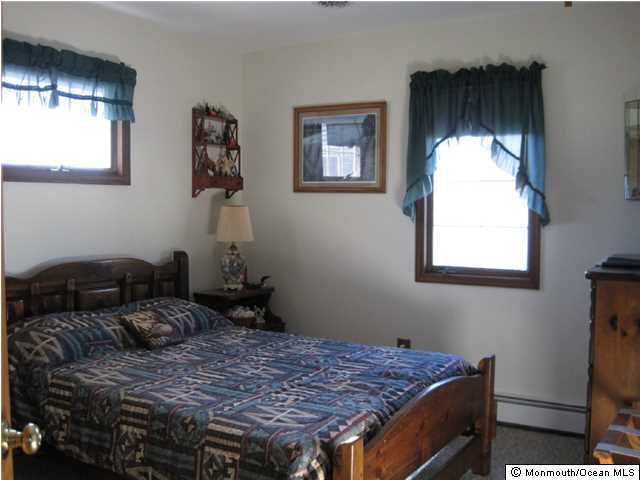 59 Spray Way Lavallette, NJ 08735 - Photo 1 of 7 a bed sitting in a bedroom next to a window