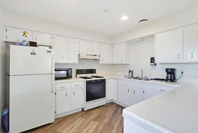 a kitchen with cabinets appliances a sink and a counter space