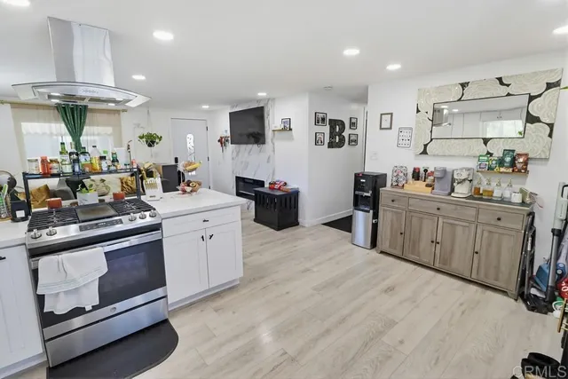 a kitchen with stainless steel appliances kitchen island granite countertop a sink cabinets and wooden floor
