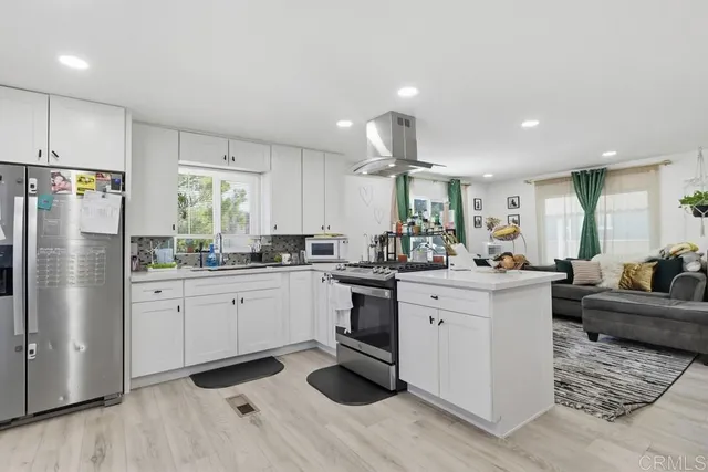 a kitchen with white cabinets and stainless steel appliances