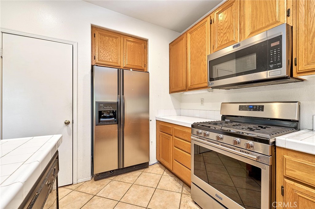 7371 Correspondence Place Rancho Cucamonga, CA 91730 - Photo 29 of 39 a kitchen with stainless steel appliances granite countertop a stove a refrigerator and a microwave