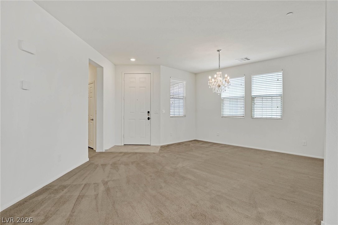 155 Fulgora Street Henderson, NV 89074 - Photo 2 of 30 A dazzling chandelier illuminates the inviting entry, complete with soft carpet flooring.