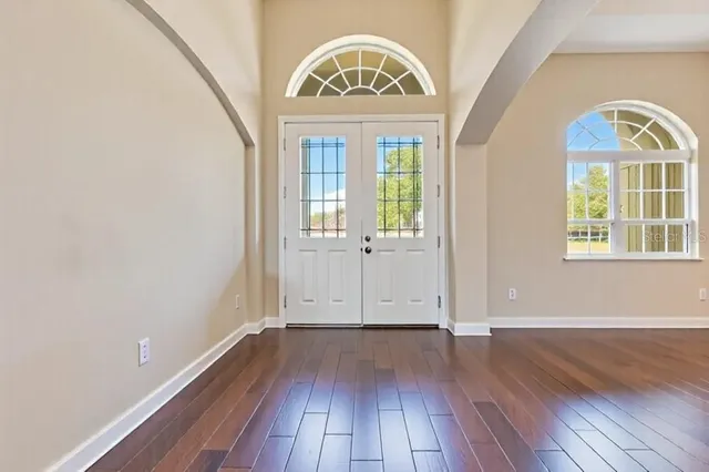 a dining room filled a chandelier and kitchen view