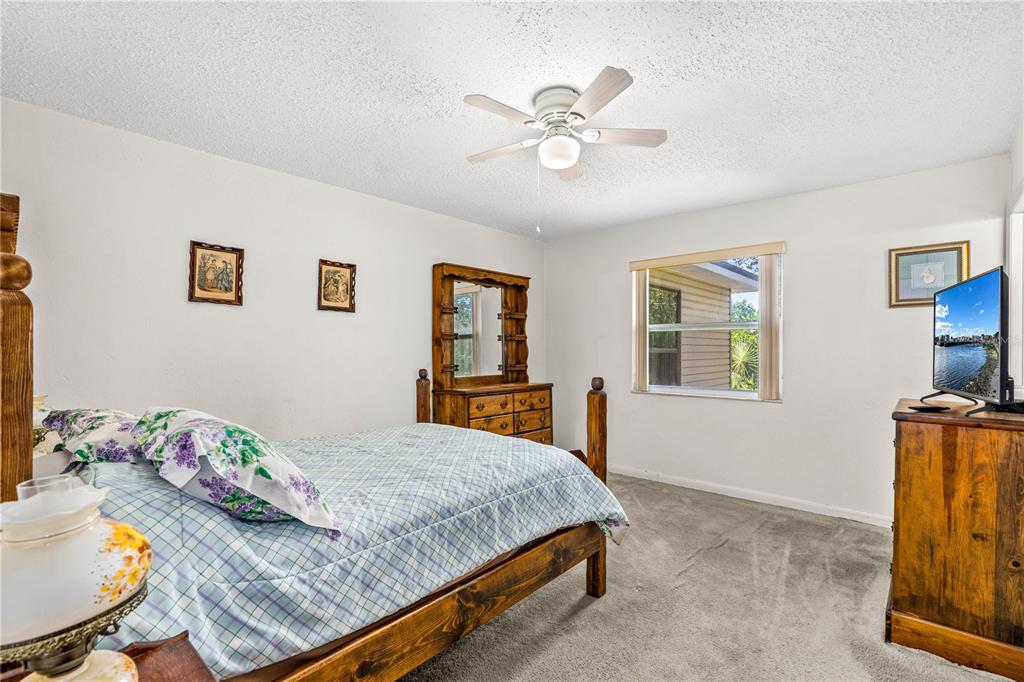 693 Reillys Road Port Orange, FL 32127 - Photo 18 of 31 a bedroom with a bed and a chandelier