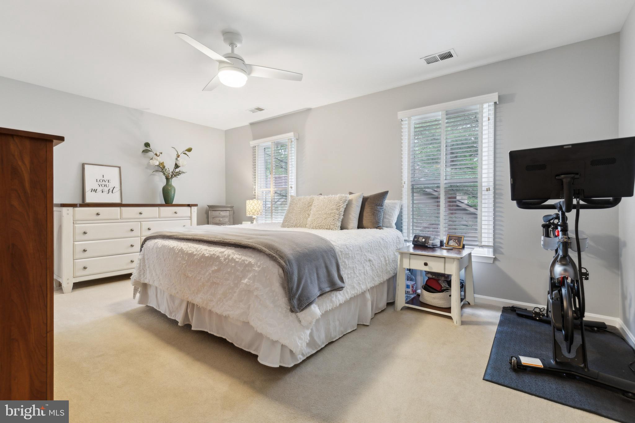 6724 Passageway Place Burke, VA 22015 - Photo 21 of 26 a bedroom with a bed a couch and a flat tv screen on the dresser