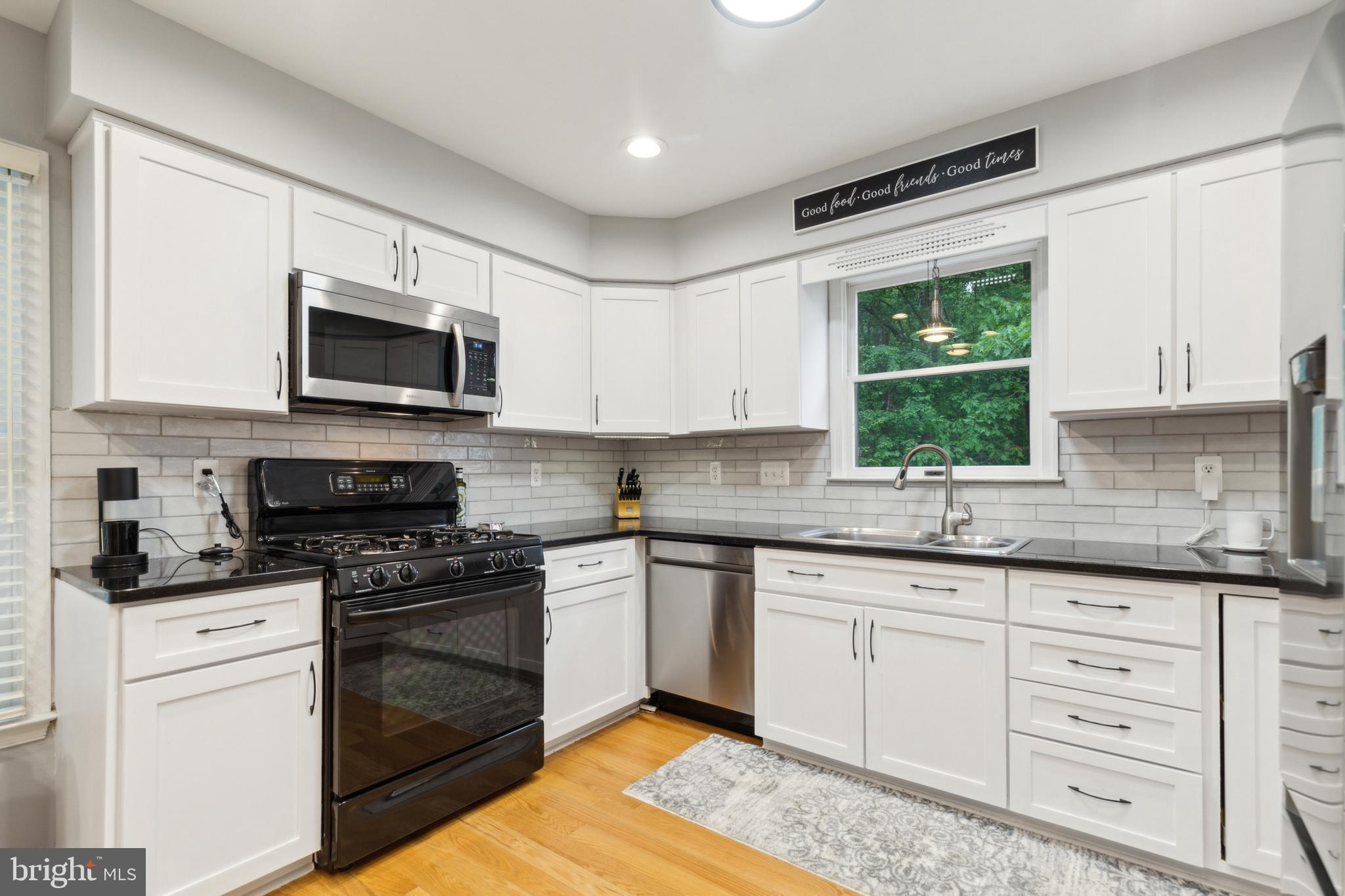 6724 Passageway Place Burke, VA 22015 - Photo 10 of 26 a kitchen with granite countertop a sink cabinets stainless steel appliances and a window