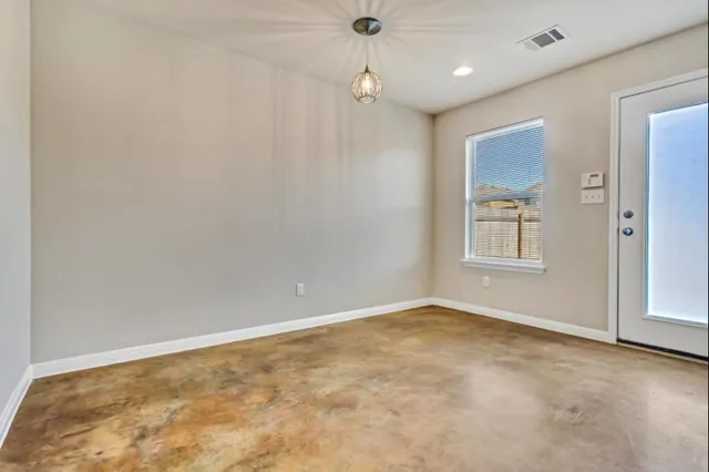 an empty room with windows and ceiling fan