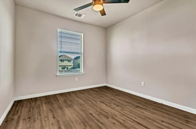 wooden floor in an empty room with a window