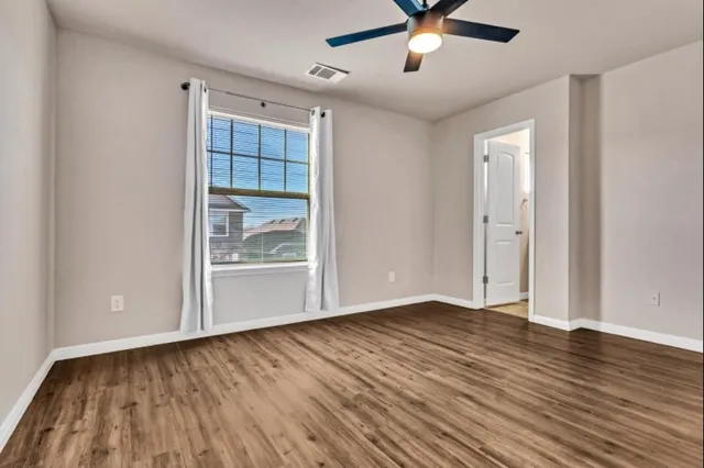 wooden floor in an empty room with a window