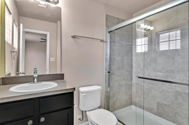 a bathroom with a sink toilet a mirror and shower