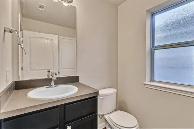 a bathroom with a sink toilet and a mirror