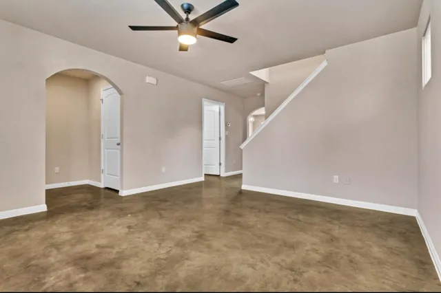 an empty room with fan and entrance