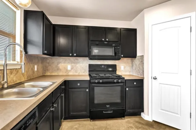 a kitchen with a sink and a stove top oven