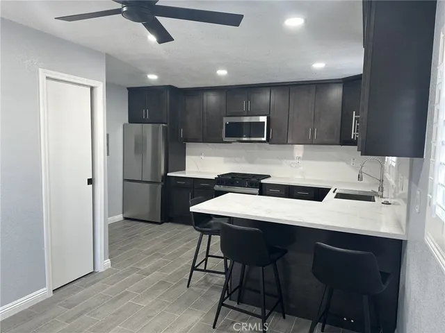 a kitchen with refrigerator cabinets and wooden floor