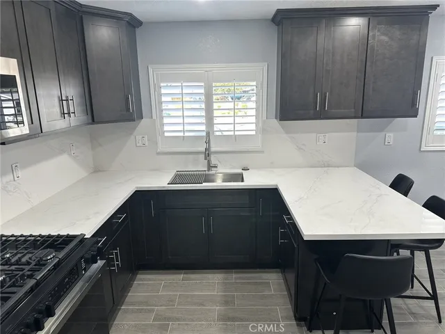 a kitchen with a sink a stove and cabinets