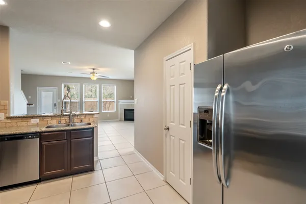 a kitchen with granite countertop a refrigerator and a sink