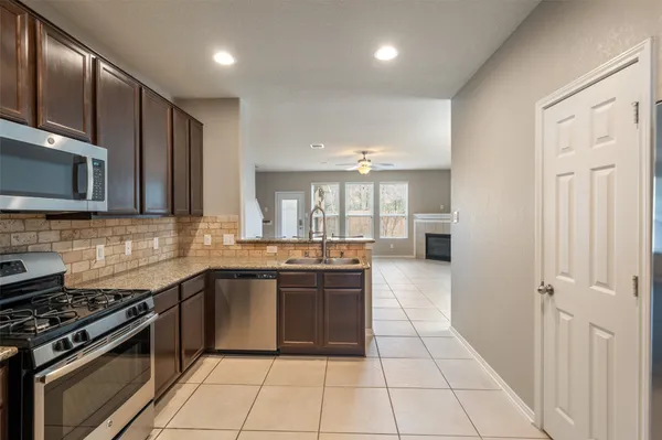 a large kitchen with stainless steel appliances granite countertop a stove and a sink