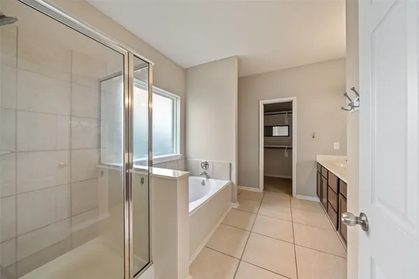 a spacious bathroom with a tub shower and a sink