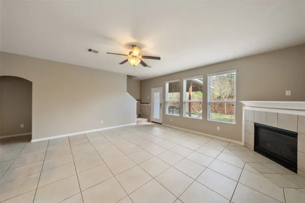 an empty room with windows and fireplace