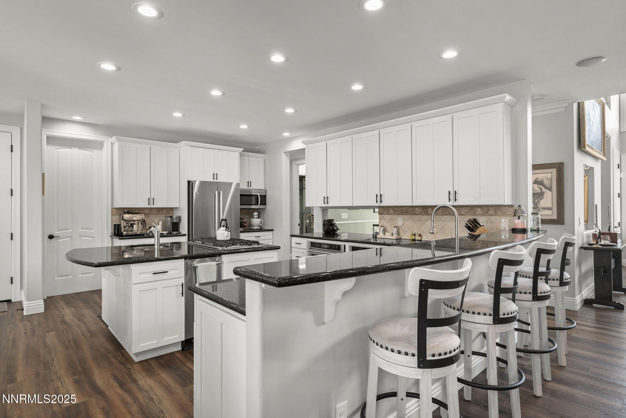 1465 Taos Lane Reno, NV 89511 - Photo 14 of 60 a kitchen with stainless steel appliances granite countertop a stove top oven a sink a refrigerator and white cabinets with wooden floor