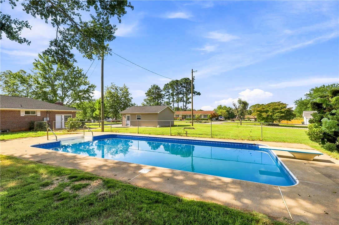 205 Timms Road Piedmont, SC 29673 - Photo 25 of 36 An inviting swimming pool anchors the spacious backyard under clear blue skies.