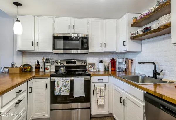 a kitchen with stainless steel appliances granite countertop a sink a stove and cabinets