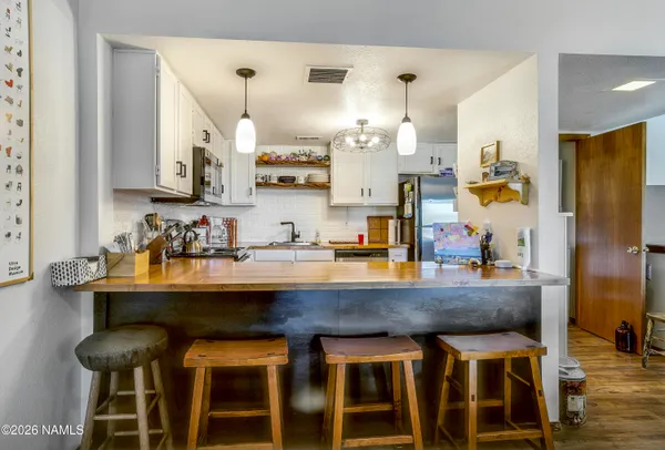 a room with granite countertop kitchen island stainless steel appliances and wooden cabinets