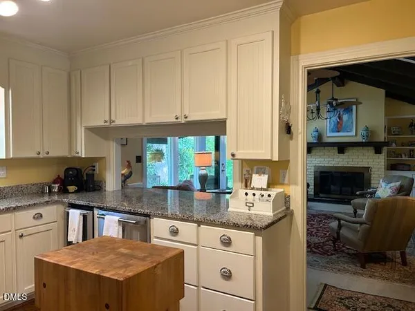 a kitchen with granite countertop kitchen island stainless steel appliances a sink stove and cabinets