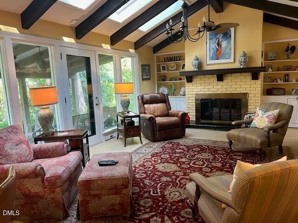 a living room with furniture fireplace and a large window
