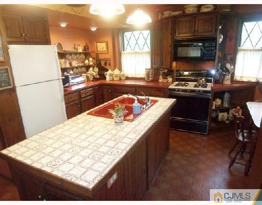 439 Chain O' Hills Road Colonia, NJ 07067 - Photo 5 of 10 a kitchen with stainless steel appliances kitchen island granite countertop a stove refrigerator sink and cabinets