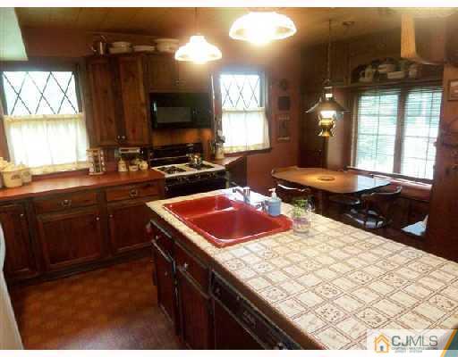 439 Chain O' Hills Road Colonia, NJ 07067 - Photo 6 of 10 a kitchen with a sink stove and cabinets