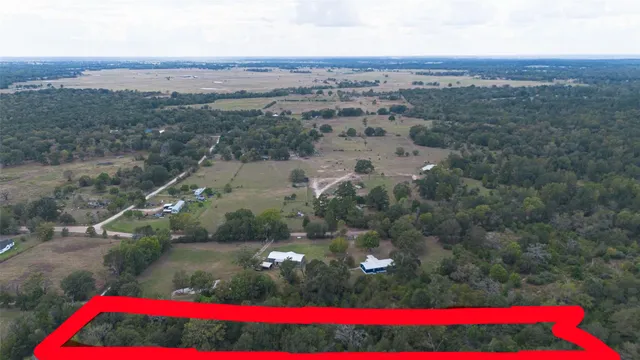 an aerial view of a houses with a lush green hillside