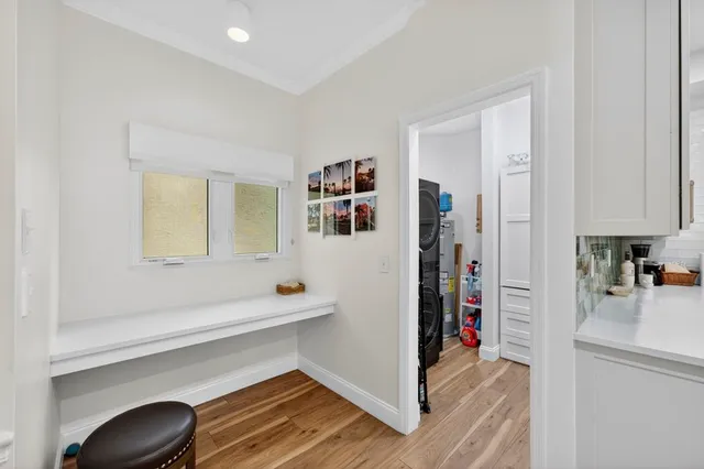 a hallway with a white cabinets a wooden floor and a sink