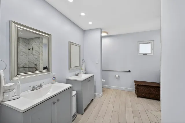 a bathroom with a double vanity sink mirror and bathtub