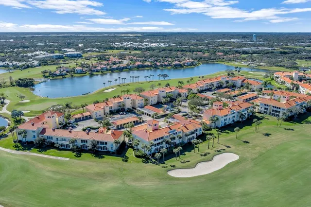 an aerial view of a house with a garden and lake view