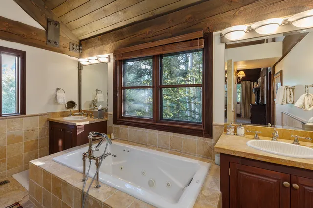 a bathroom with a sink a mirror a toilet and shower