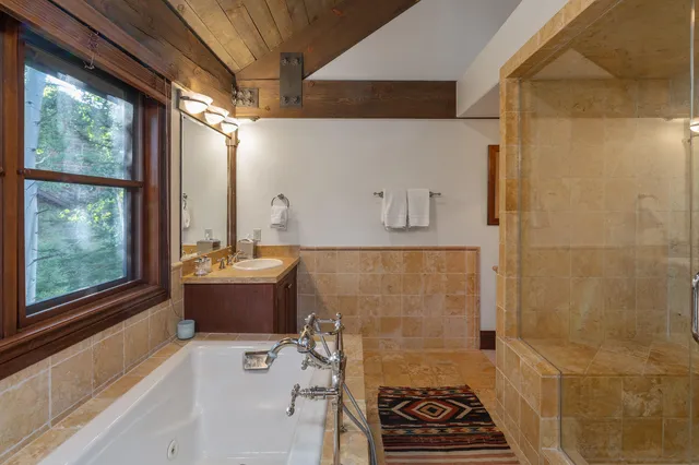 a view of a house with a small yard and large trees