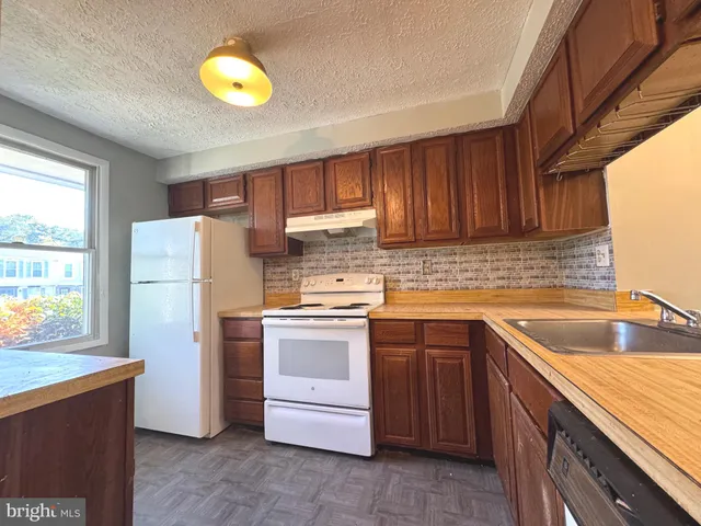 a kitchen with a sink stove and refrigerator