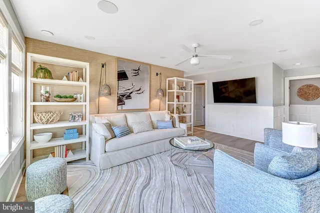 a living room with furniture a flat screen tv and a large window