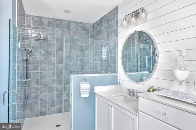a bathroom with a granite countertop sink a mirror and a shower