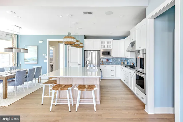 a large kitchen with white cabinets and stainless steel appliances